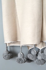 Natural Cotton Throw With Steel Gray Pom Poms from Yuba Mercantile